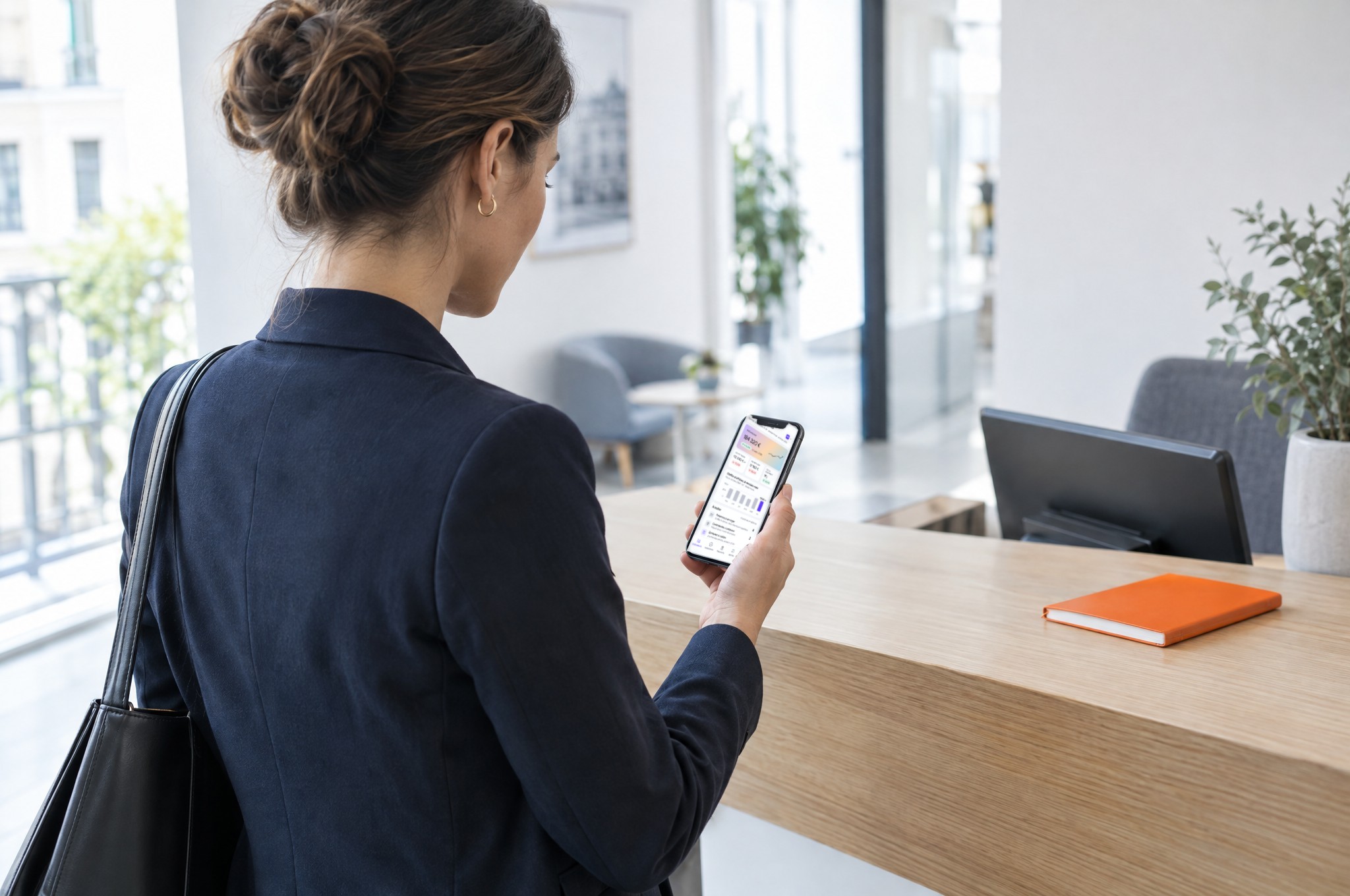 Commerciale consultant ses indicateurs Kordeos sur son téléphone, à l'accueil d'un client
